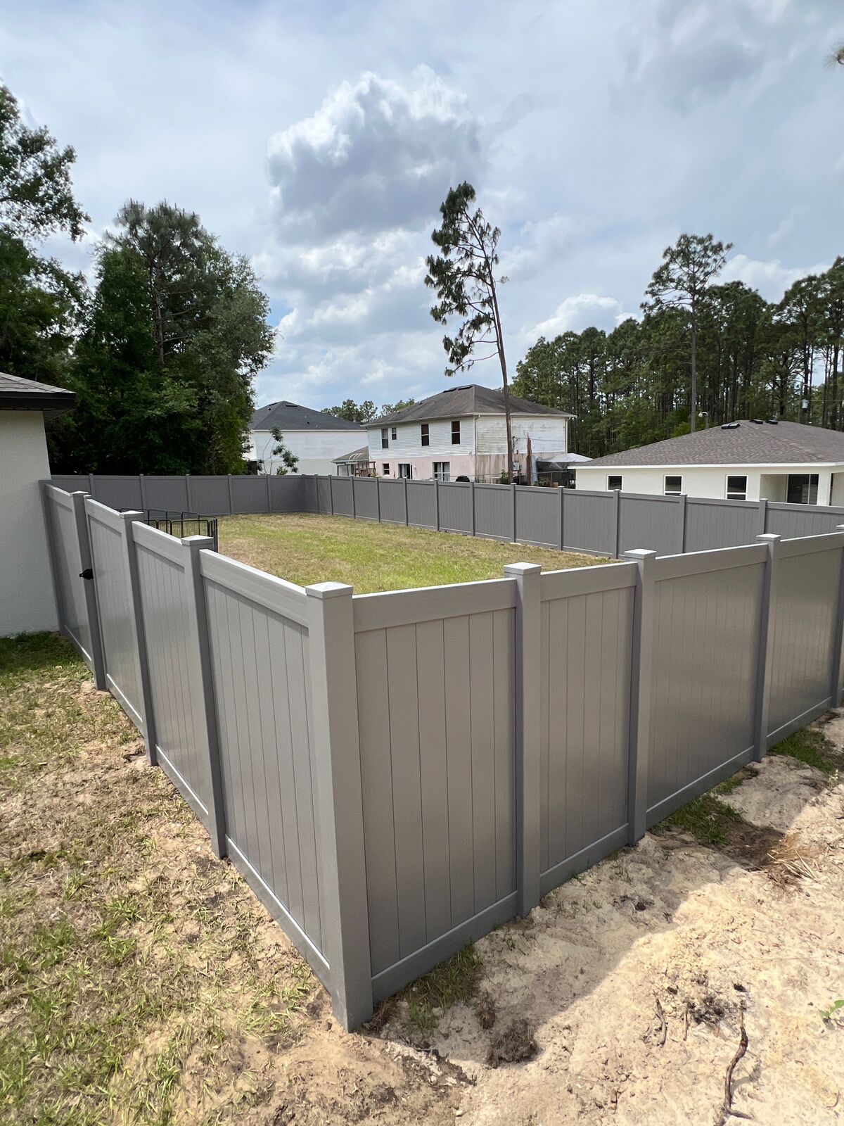 Gray vinyl privacy fence around a Florida backyard installed by Florida Friendly Fencing
